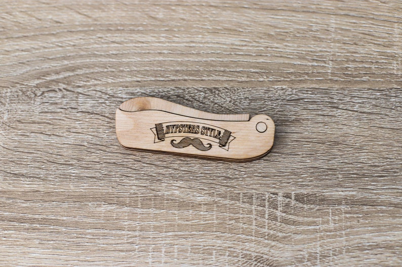 Op de afbeelding: Een houten kam met een gebogen handvat en een snorontwerp. De kam is gegraveerd met de woorden "Hipsters Style".