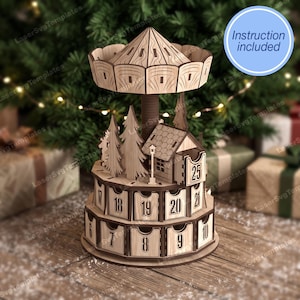 Può includere: Un carosello calendario dell'avvento in legno a più livelli con tetto conico, pilastro centrale e piccoli cassetti numerati da 6 a 25. La struttura include sagome di pini tagliate al laser e una piccola baita. Un cerchio blu contiene il testo Instruction included.