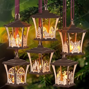 Può includere: Un set di cinque lanterne decorative in legno da appendere con intricate scene natalizie tagliate al laser. Ogni lanterna presenta una cornice marrone scuro con sagome in legno chiaro che raffigurano un pupazzo di neve, renne, un angelo, un bosco.