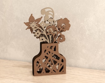 May include: A wooden vase with a geometric pattern design holds a bouquet of brown and beige paper flowers.