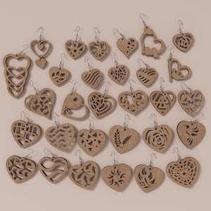 May include: A collection of wooden heart-shaped earrings with various cutout designs. The earrings are light brown and feature intricate patterns, including geometric shapes, floral motifs, and openwork designs. Each earring hangs from a silver-colored hook.