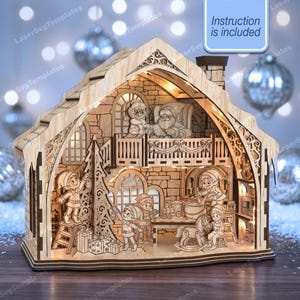 May include: A laser-cut wooden diorama of a two-story workshop featuring Santa Claus and elves. The structure includes intricate wall patterns, a balcony, and interior lighting. The text "Instruction is included" appears in a blue box.