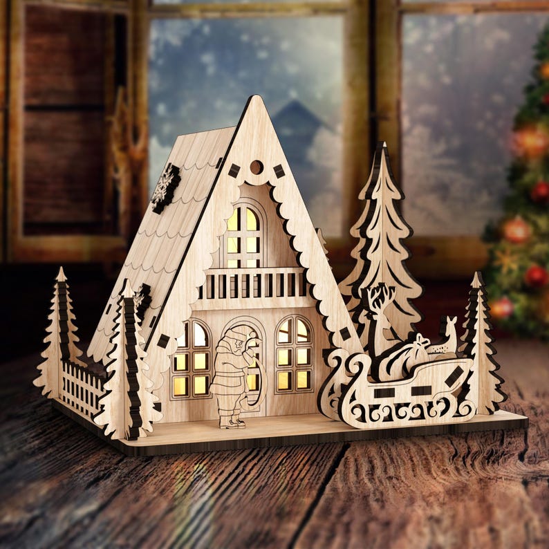 May include: A wooden Christmas village scene with a lit-up house, a sleigh pulled by reindeer, and pine trees. The house has a white roof and a brown wooden frame. The sleigh is brown and has a white trim. The pine trees are green and have white snow on them.
