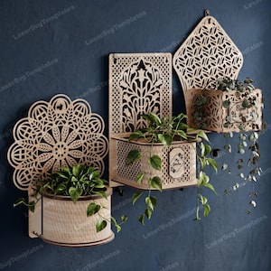 May include: Three wall-mounted wooden planters with intricate laser-cut backings. One features a circular mandala design, one a rectangular floral pattern, and one a diamond shape. Two planters have small plaques reading My Garden and Bloom.