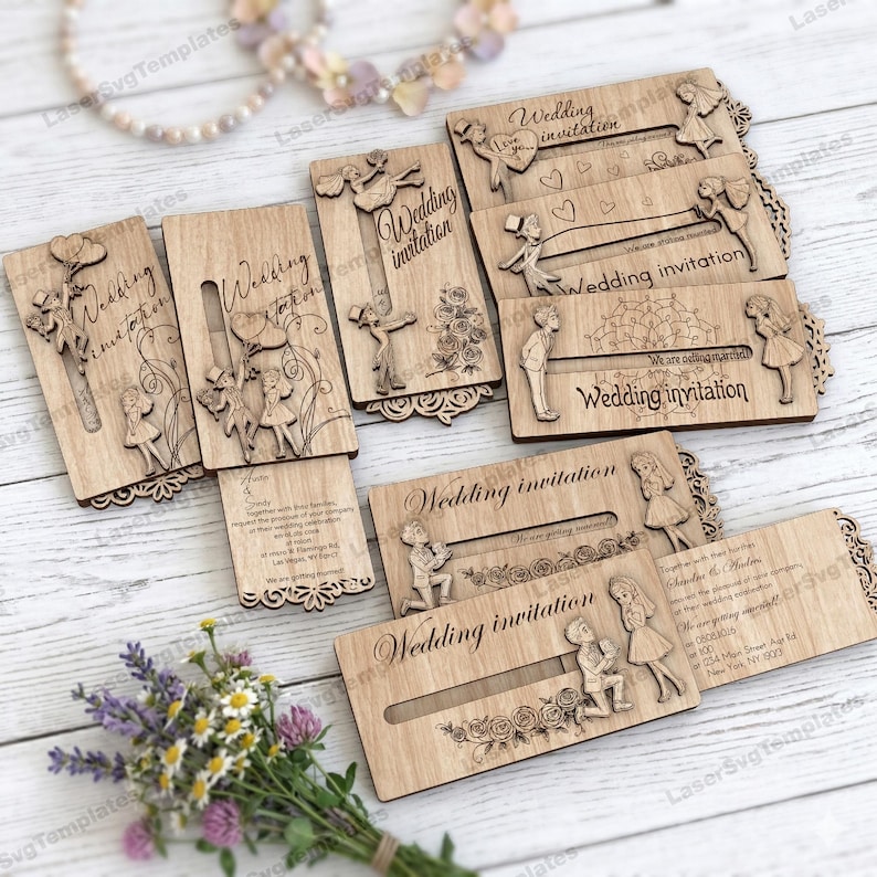 May include: A collection of laser-cut wooden wedding invitations. Each invitation features intricate designs of couples, flowers, and decorative borders. The words "Wedding invitation" are engraved on the front of each card. Some cards have additional text.