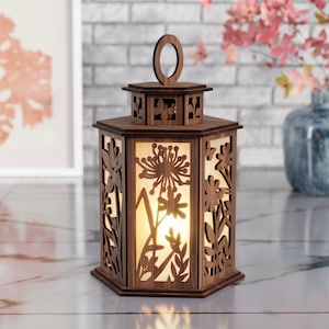 May include: A wooden lantern with a hexagonal shape and intricate floral designs cut out. The lantern has a warm, glowing light inside.