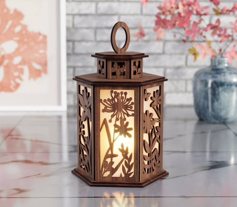 May include: A wooden lantern with a hexagonal shape and intricate floral designs cut out. The lantern has a warm, glowing light inside.
