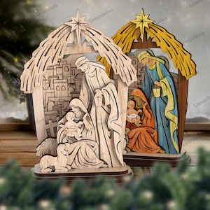 Può includere: Due statuine del presepe in legno. Una non è verniciata, l'altra è dipinta con giallo, blu e arancione. Ognuna presenta una stella in cima e raffigura la sacra famiglia in un ambiente di stalla. Le statuine sono su una base di legno.