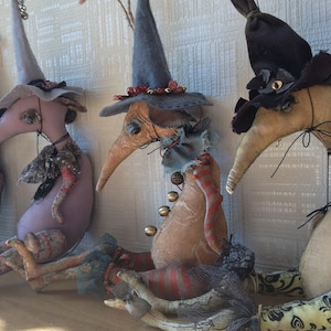 Könnte beinhalten: Drei handgefertigte Filz-Hexenpuppen mit spitzen Hüten und langen Nasen. Die Puppen tragen bunte Kleidung und haben einen skurrilen, Vintage-Look.