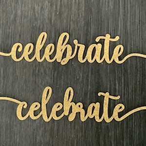 Può includere: Due cartelli in legno color oro con la parola "celebrate" scritta in corsivo su ogni cartello. I cartelli sono su uno sfondo in legno grigio scuro.