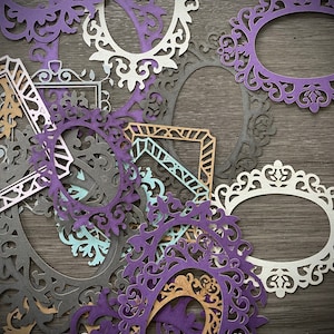 May include: A collection of decorative paper frames in various colors and patterns, including purple, white, brown, and blue. The frames are intricately designed with ornate details and are arranged in a random pattern.