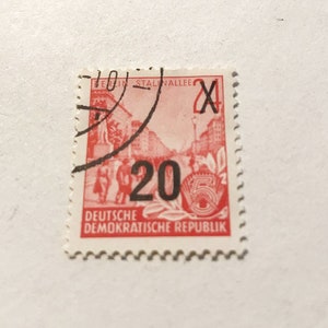 May include: A red and black stamp from the Deutsche Demokratische Republik (German Democratic Republic) with the number 20 and the text "Berlin Stalinallee" and "X".