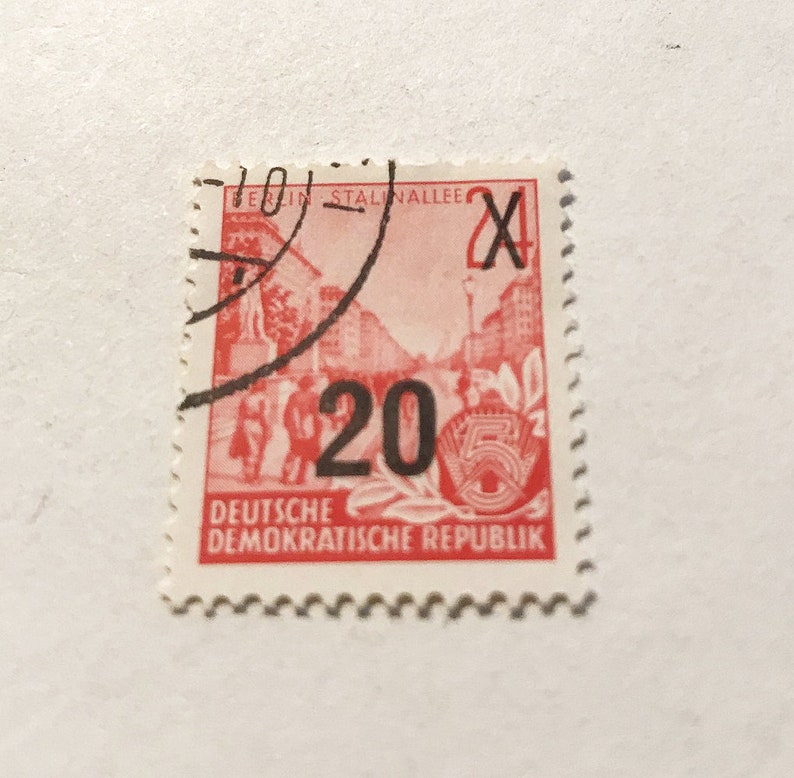 May include: A red and black stamp from the Deutsche Demokratische Republik (German Democratic Republic) with the number 20 and the text "Berlin Stalinallee" and "X".