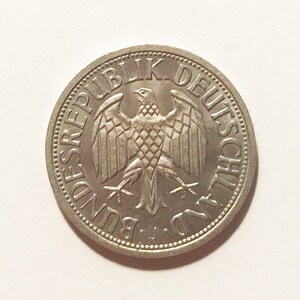 May include: A silver German coin with the text "Bundesrepublik Deutschland" and a stylized eagle in the center.