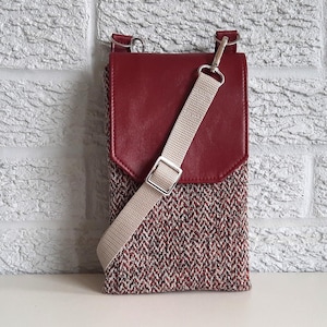 Bolso bandolera para teléfono hecho a mano con tela de espiga de henna leonado, con solapa de piel sintética burdeos y bolsillo trasero con cremallera.