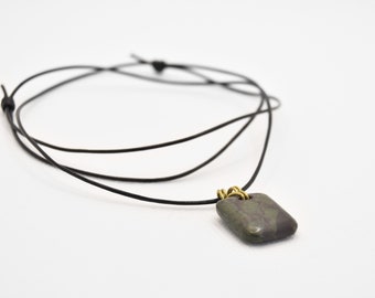 Dark green stone with brass wire on a thin, black leather chain (unique)