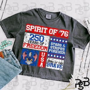 Puede incluir: Camiseta gris oscuro con un diseño patriótico. La camiseta presenta el texto "SPIRIT OF '76" y "250 YEARS OF FREEDOM" en rojo, blanco y azul. También se incluye un gráfico de un águila y las palabras "USA" y "HOME OF THE BRAVE".