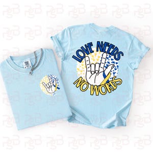 May include: Two light blue t-shirts with the phrase "LOVE NEEDS NO WORDS" and a hand gesture graphic. One shirt has the graphic on the front, the other on the back. A silver chain necklace is on the front shirt.
