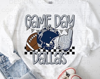 May include: White sweatshirt with a "Game Day Dallas" graphic. The design includes a football, helmet, and a foam finger. The text is in a gray, outlined font, with a black and white checkered pattern.