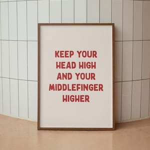 May include: A framed print with a white background and red text that reads "Keep your head high and your middle finger higher."
