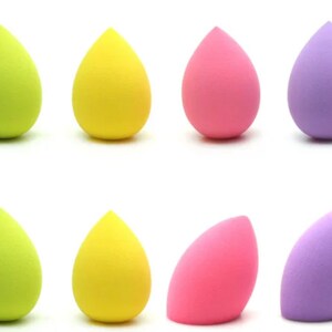 May include: Eight makeup sponges in various colors, including yellow, green, pink, and purple. The sponges are teardrop shaped and designed for blending makeup.
