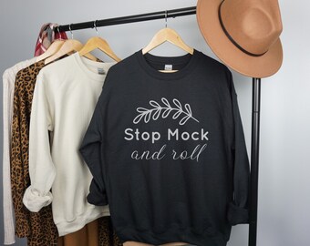 May include: Black sweatshirt with a white graphic that says "Stop Mock and roll" with a small branch design above the text.