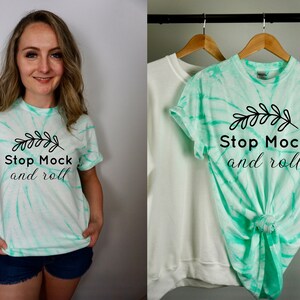 May include: A tie-dye t-shirt in shades of green and white with the text "Stop Mock and roll" and a small leaf design.