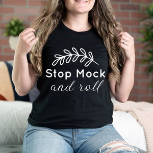 May include: A black t-shirt with a white graphic of a branch and the text "Stop Mock and roll".