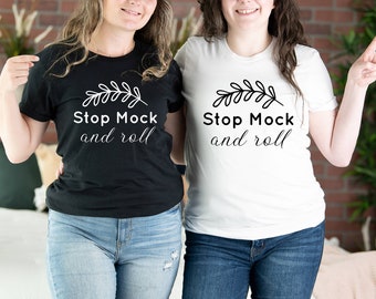 May include: Two people wearing black and white t-shirts with the text "Stop Mock and roll" and a small leaf design. The person on the left is wearing blue jeans and the person on the right is wearing dark blue jeans.