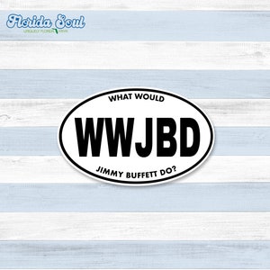 Pode incluir: Etiqueta oval branca com texto preto que diz "What Would Jimmy Buffett Do?" e "WWJBD". A etiqueta está em um fundo de madeira branco e azul claro.