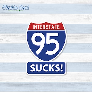 May include: A blue and red interstate highway sign with the number 95 and the text "INTERSTATE" above the number. Below the sign is a white rectangle with the text "SUCKS!" in blue letters.