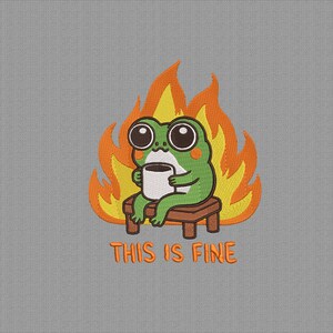 May include: Embroidered image of a green frog with large eyes, holding a coffee cup, sitting on a small wooden bench in front of orange and yellow flames. The text "THIS IS FINE" is below the frog.