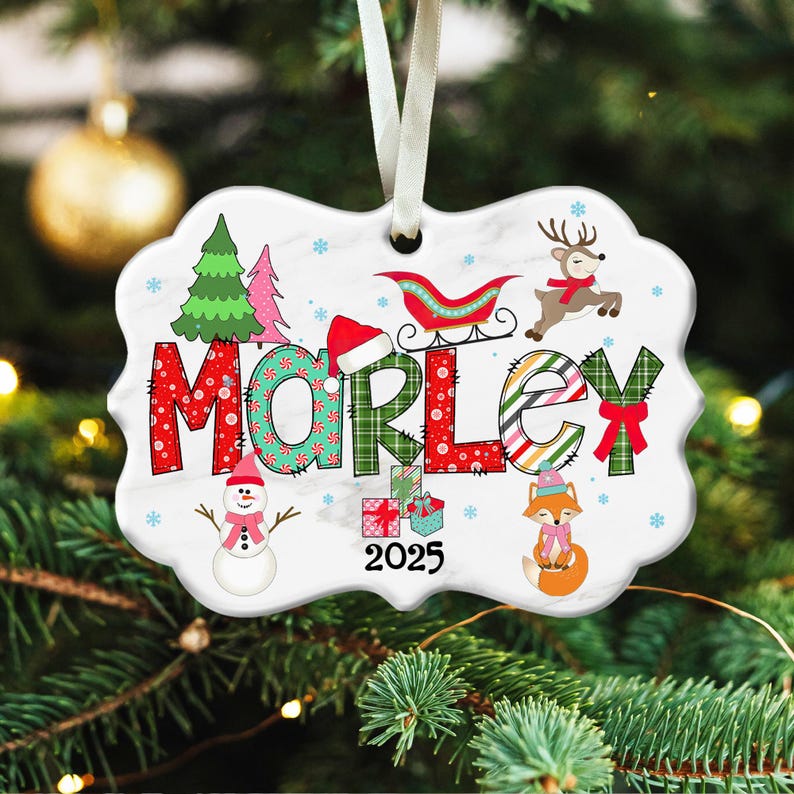 May include: A white ceramic Christmas ornament with a scalloped edge, featuring the name "MORLEY" in festive lettering. The design includes a Christmas tree, snowman, reindeer, fox, and the year 2025. A white ribbon is attached for hanging.