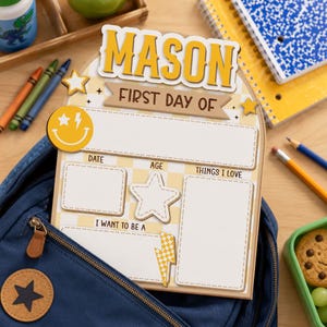 May include: A wooden arch-shaped sign with a yellow and white checkered pattern, featuring the name MASON and the text FIRST DAY OF. It includes blank sections for date, age, things I love, and career goals, decorated with a smiley face and stars.