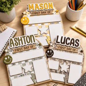 May include: Three arched wooden signs for a first day of school, personalized with the names Mason, Ashton, and Lucas. Each sign features a blank area for date, age, things I love, and future career goals, decorated with stars, lightning bolts, and smiley faces.