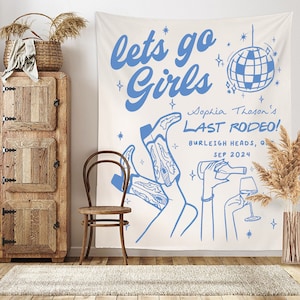 May include: A white tapestry with blue text that reads "lets go Girls" and "Sophia Thoson's LAST RODEO!" with a disco ball graphic and a drawing of two legs wearing cowboy boots.