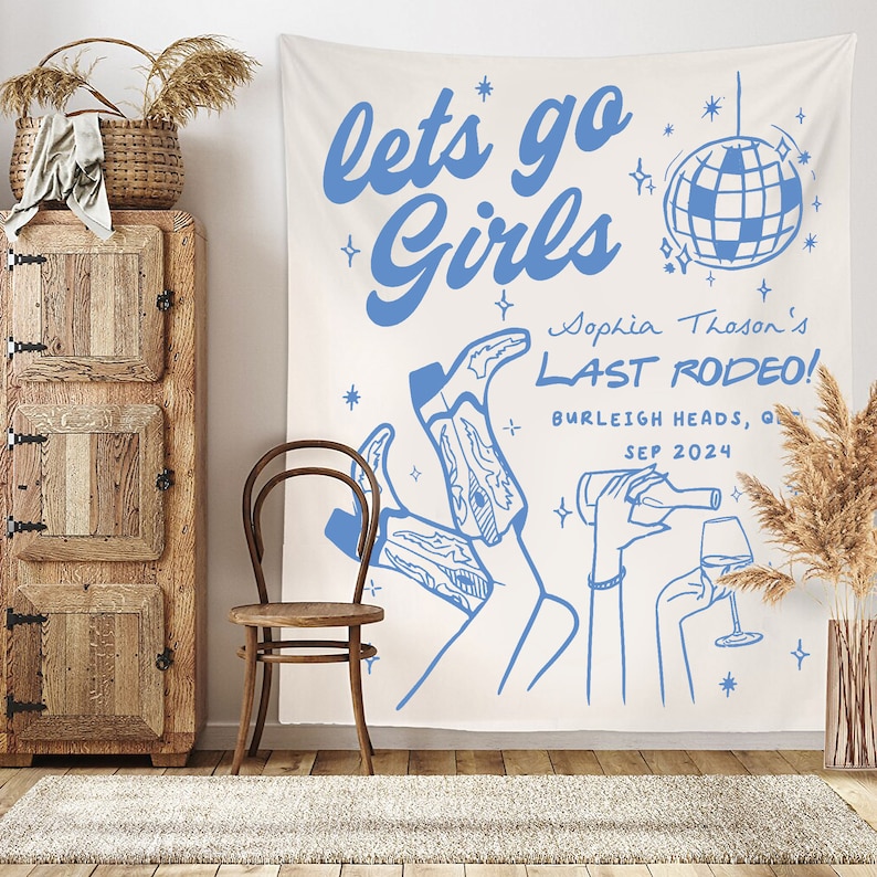May include: A white tapestry with blue text that reads "lets go Girls" and "Sophia Thoson's LAST RODEO!" with a disco ball graphic and a drawing of two legs wearing cowboy boots.