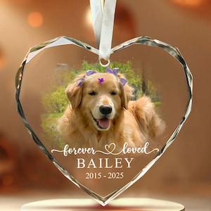 May include: Heart-shaped crystal ornament featuring a golden retriever with a purple flower crown. The ornament has the words "forever loved" and the name "BAILEY" with the years "2015-2025" in white script.