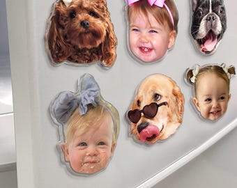May include: A collection of clear, glossy magnets featuring images of a dog, babies, and a dog wearing heart-shaped sunglasses. The magnets are in various shapes and sizes, with a white background.