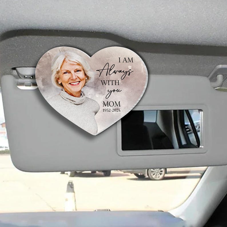 May include: A heart-shaped car visor clip with a watercolor background and a photo of a woman. The text reads "I am Always With You Mom 1952-2024".