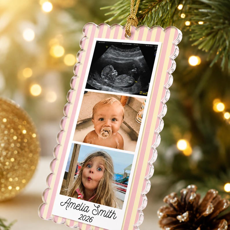 May include: A rectangular acrylic ornament with scalloped edges and a light pink and yellow vertical striped border. It features three stacked photos: an ultrasound, a baby with a pacifier, and a young girl. The name Amelia Smith and 2026 are printed.