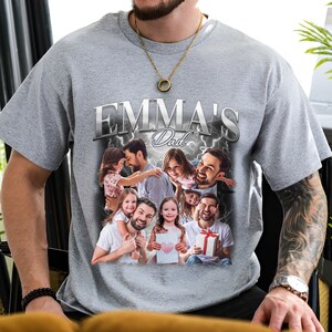 Peut inclure: Un t-shirt gris avec un graphique argent&eacute; qui dit "Emma's Dad" avec un collage de photos d'un homme et d'enfants.