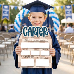 Op de afbeelding: Een kind in een afstudeerhoed en toga houdt een houten bord vast. Het bord zegt "CARTER" bovenaan en heeft vakken voor "DATUM", "LEEFTIJD", "LENGTE", "ALS IK GROOT BEN WIL IK WORDEN" en "Dingen die ik leuk vind". De tekst "VANDAAG IS MIJN LAATSTE DAG VAN" staat er ook op.