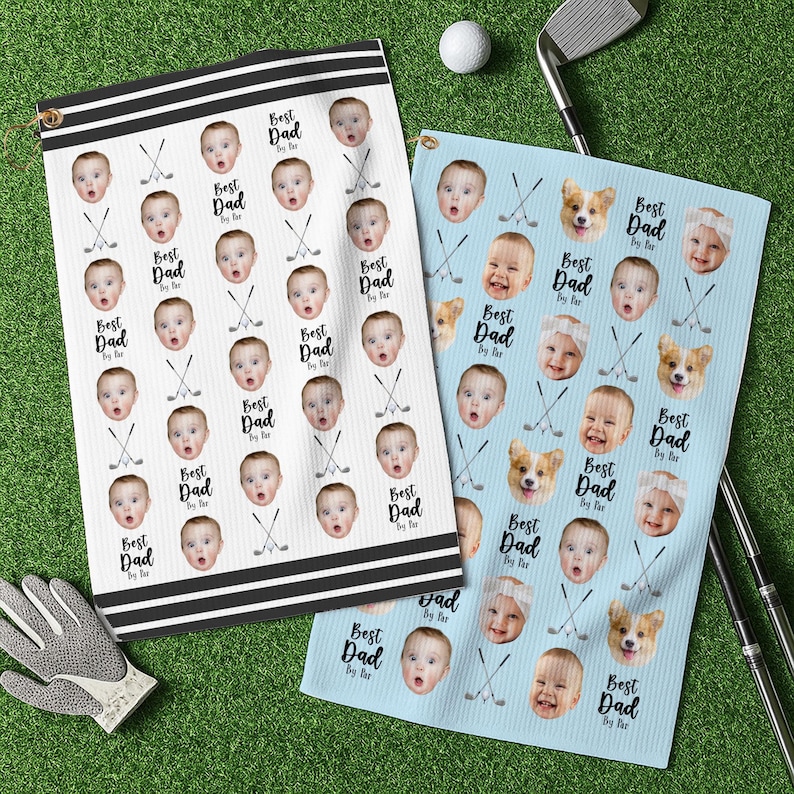 May include: Two golf towels featuring baby faces and the text "Best Dad By Far". One is white with black stripes, the other light blue. Golf clubs, a golf ball, and a golf glove are also visible.