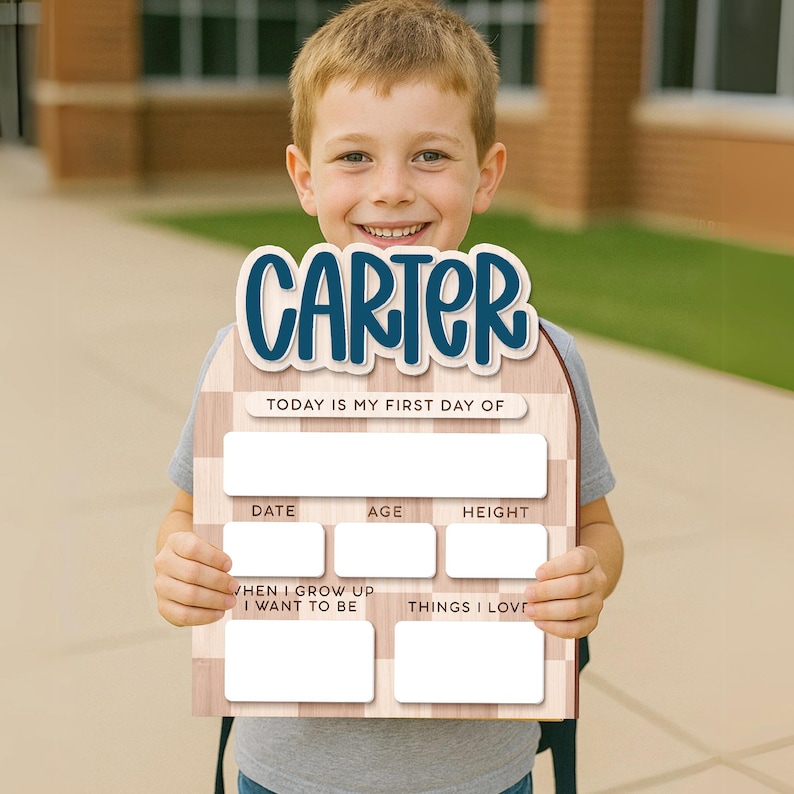 Op de afbeelding: Een houten bord met de naam "CARTER" in blauw schrift. Het bord heeft vakken om de datum, leeftijd, lengte, toekomstige ambities en favoriete dingen op te schrijven. De tekst "TODAY IS MY FIRST DAY OF" is ook zichtbaar.