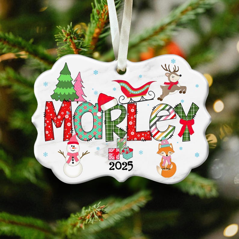 May include: A decorative Christmas ornament with the name "MORLEY" in festive lettering. The ornament features a snowman, fox, reindeer, and a sleigh, along with the year "2025". The background is white with snowflakes.