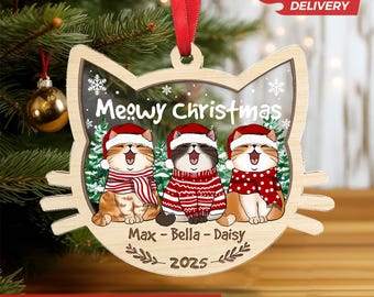May include: Wooden cat-shaped Christmas ornament with three cartoon cats wearing Santa hats and scarves. The ornament says "Meowy Christmas" and includes the names "Max - Bella - Daisy" and the year "2025". A red ribbon is attached for hanging.
