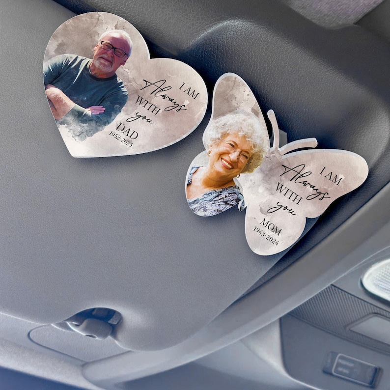 May include: Two car air fresheners with watercolor backgrounds. One is a heart shape with a photo of a man and the text "I am always with you. Dad 1952-2025". The other is a butterfly shape with a photo of a woman and the text "I am always with you. Mom 1943-2024".