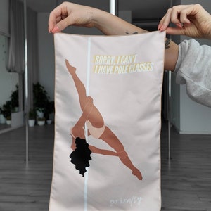 Peut inclure: Une serviette en tissu rose avec une silhouette d'une femme faisant un mouvement de pole dance. Le texte "Sorry, I can't I have pole classes" est imprimé en jaune sur la serviette. Le texte "go krafty" est imprimé en blanc en bas de la serviette.
