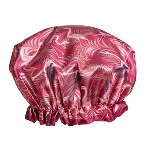 May include: A pink satin shower cap with a flamingo and palm leaf print.